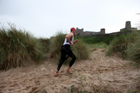 In transition from swimming to cycle during the Bamburgh Triathlon with Bamburgh Castle as a backdrop as the rain starts